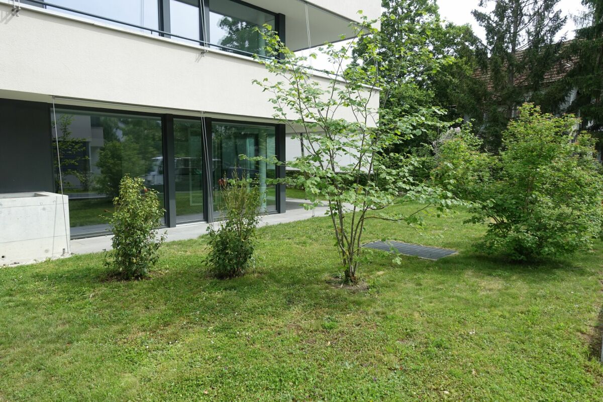 Moderner Garten mit großflächiger Glasfassade