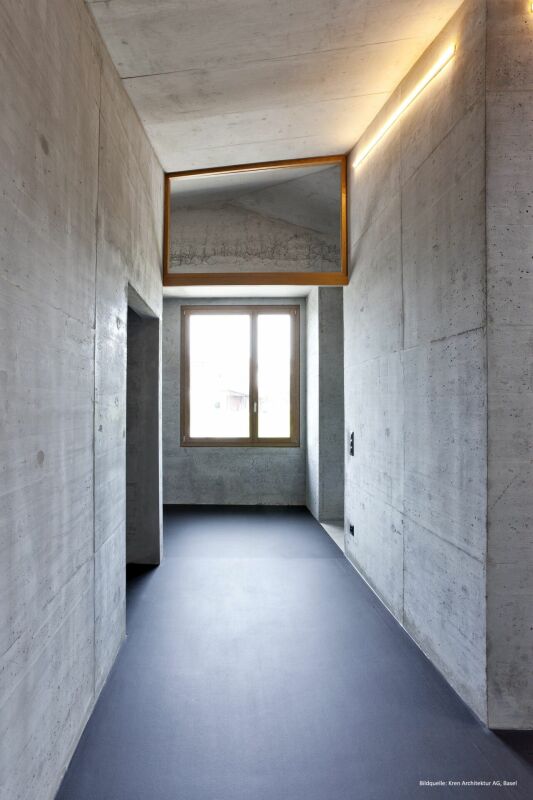 Minimalistischer Betonkorridor mit Oberlicht und Fenster