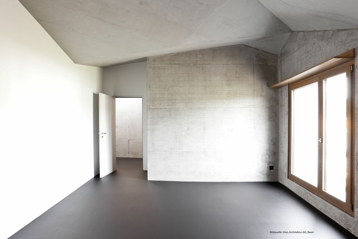 Minimalistischer Rohbau-Raum mit Betonwänden und Holzfenster