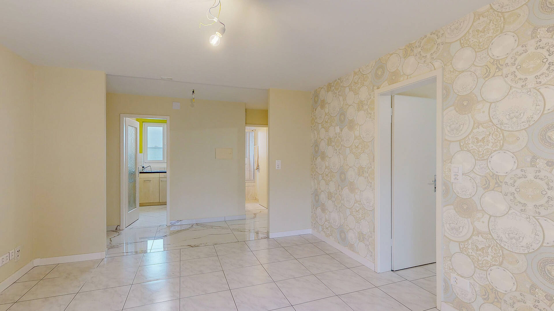Heller Wohnraum mit Fliesenboden und Musterwand