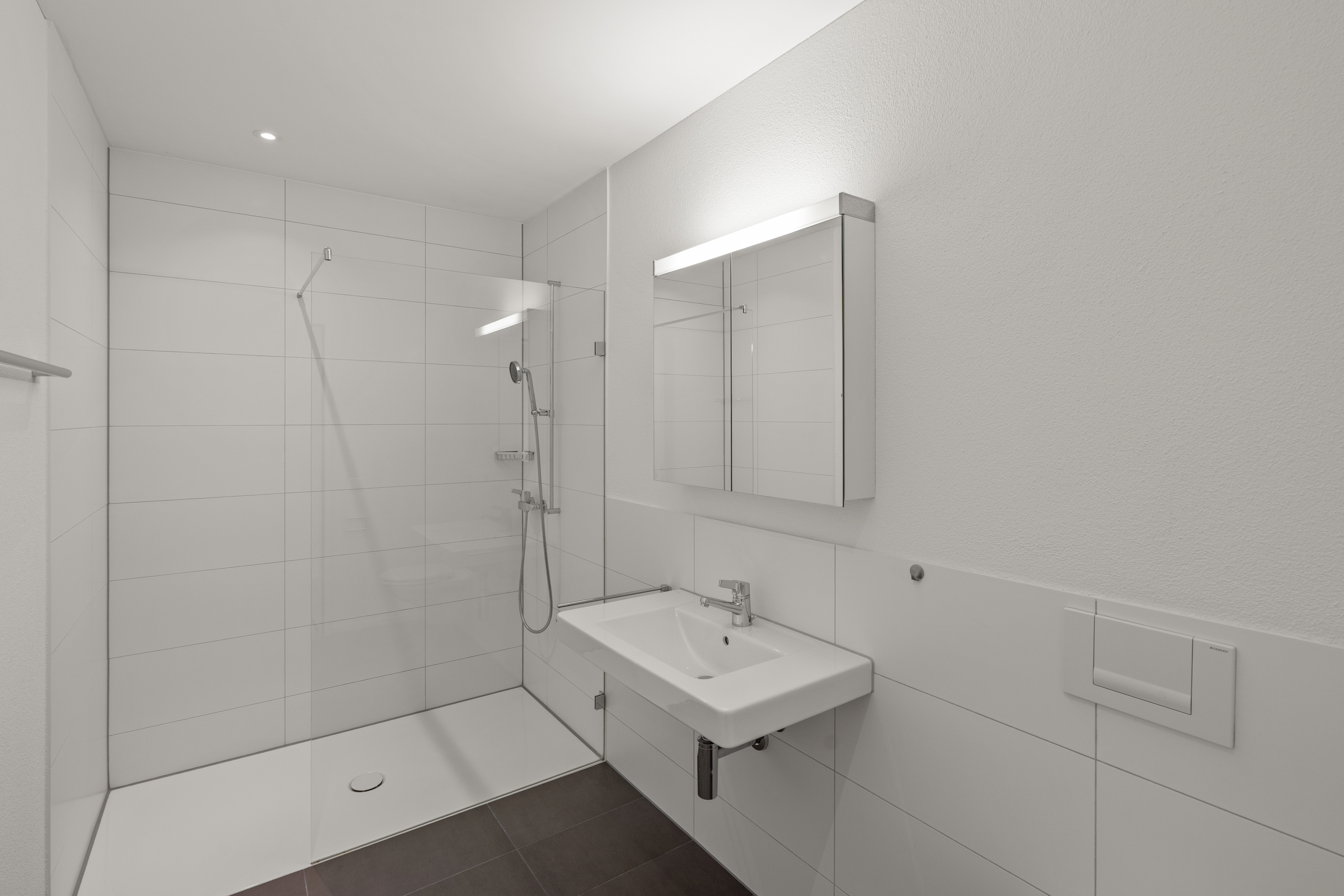 Modernes, helles Badezimmer mit Dusche und Waschtisch