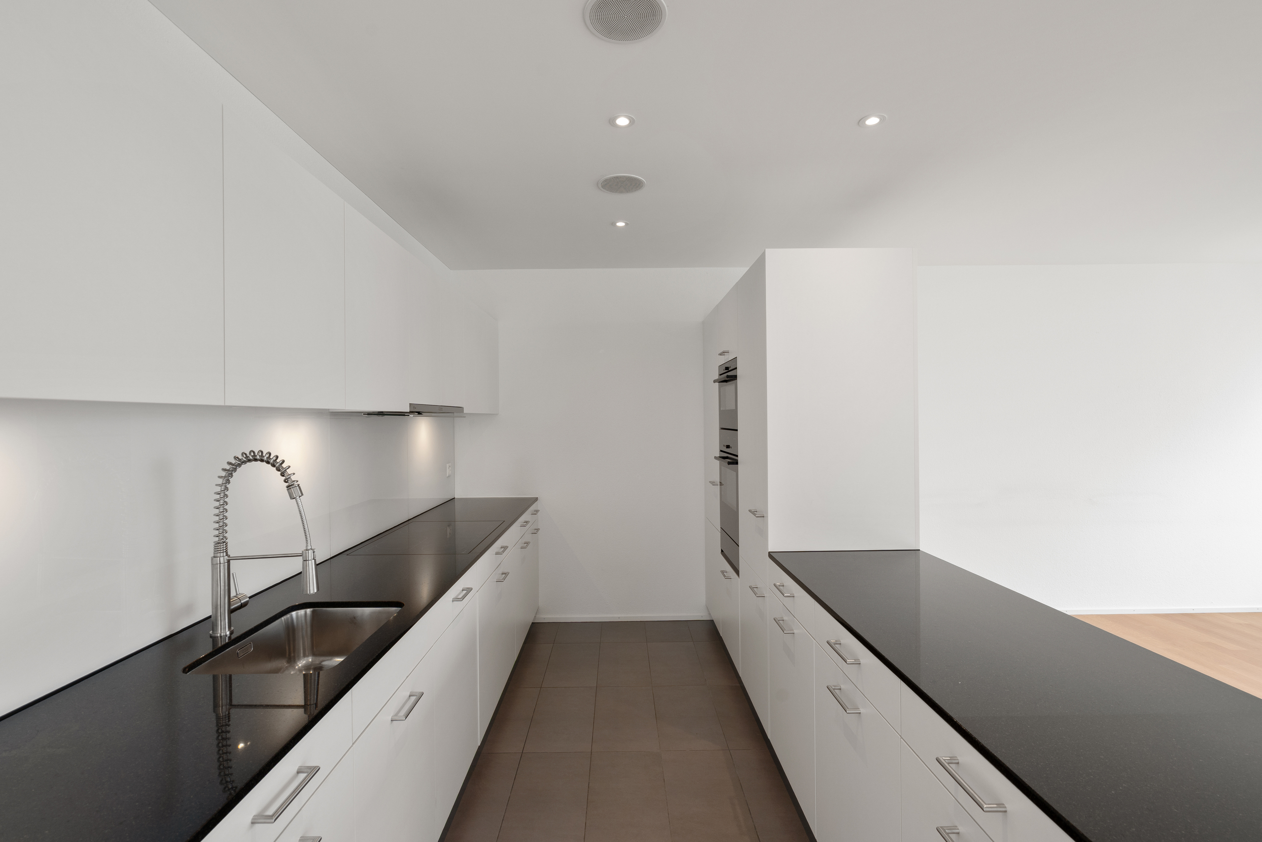 Moderne, minimalistische Küche mit dunkler Arbeitsplatte