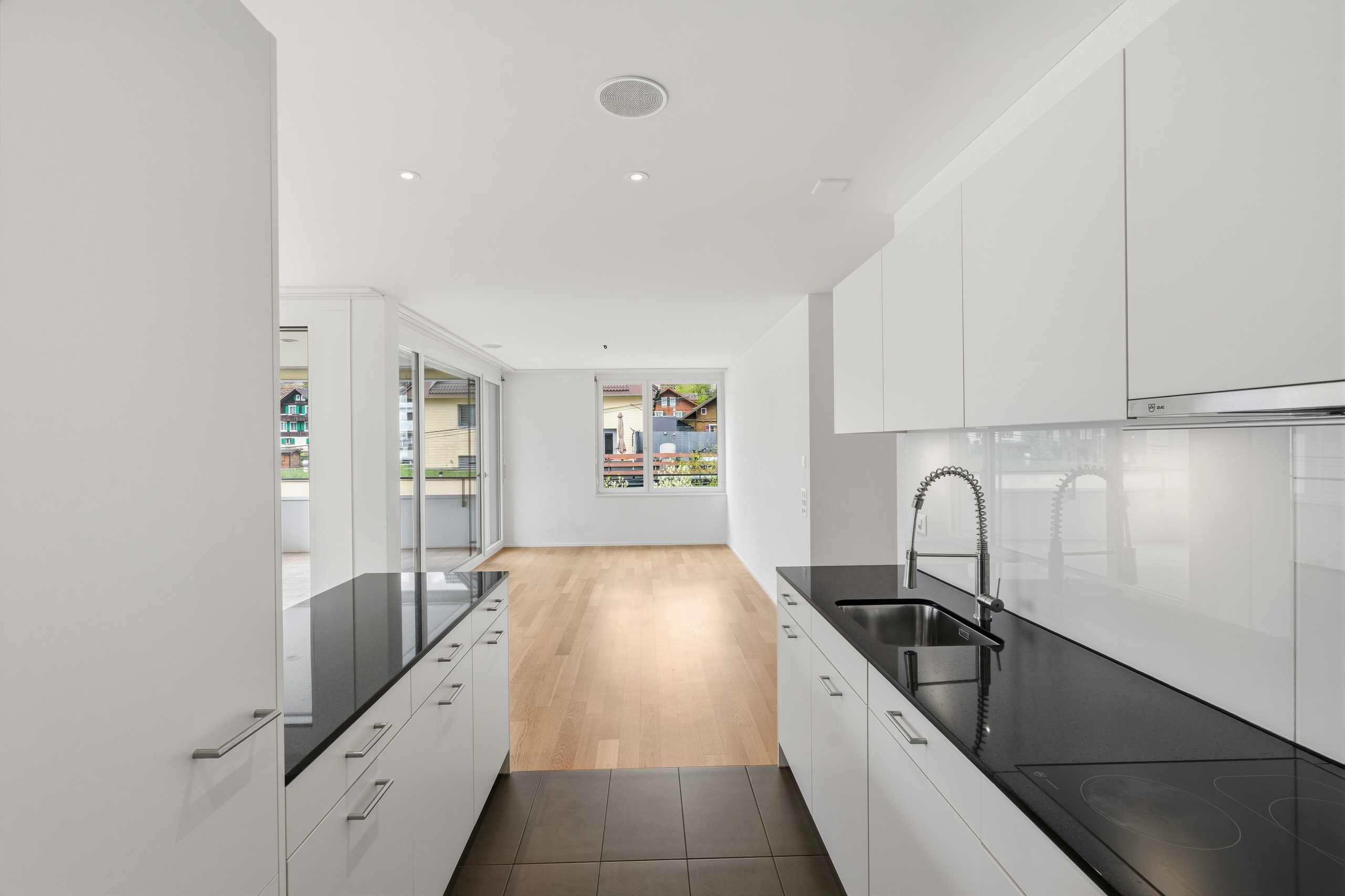 Moderne, helle Küche mit Blick in den Wohnbereich