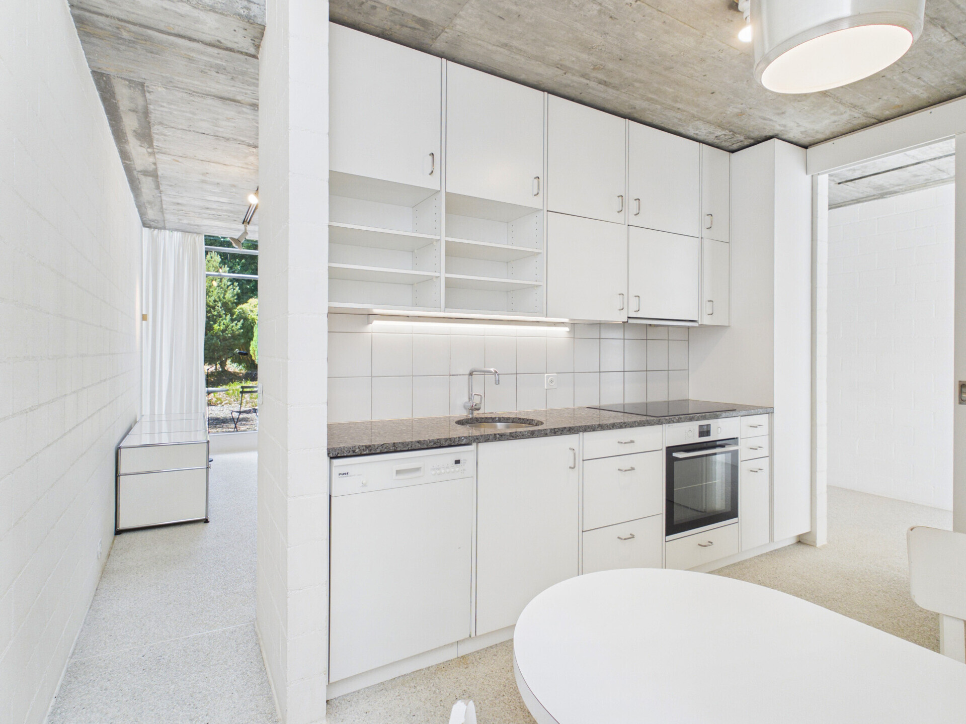 Moderne offene Küche mit Sichtbeton-Decke