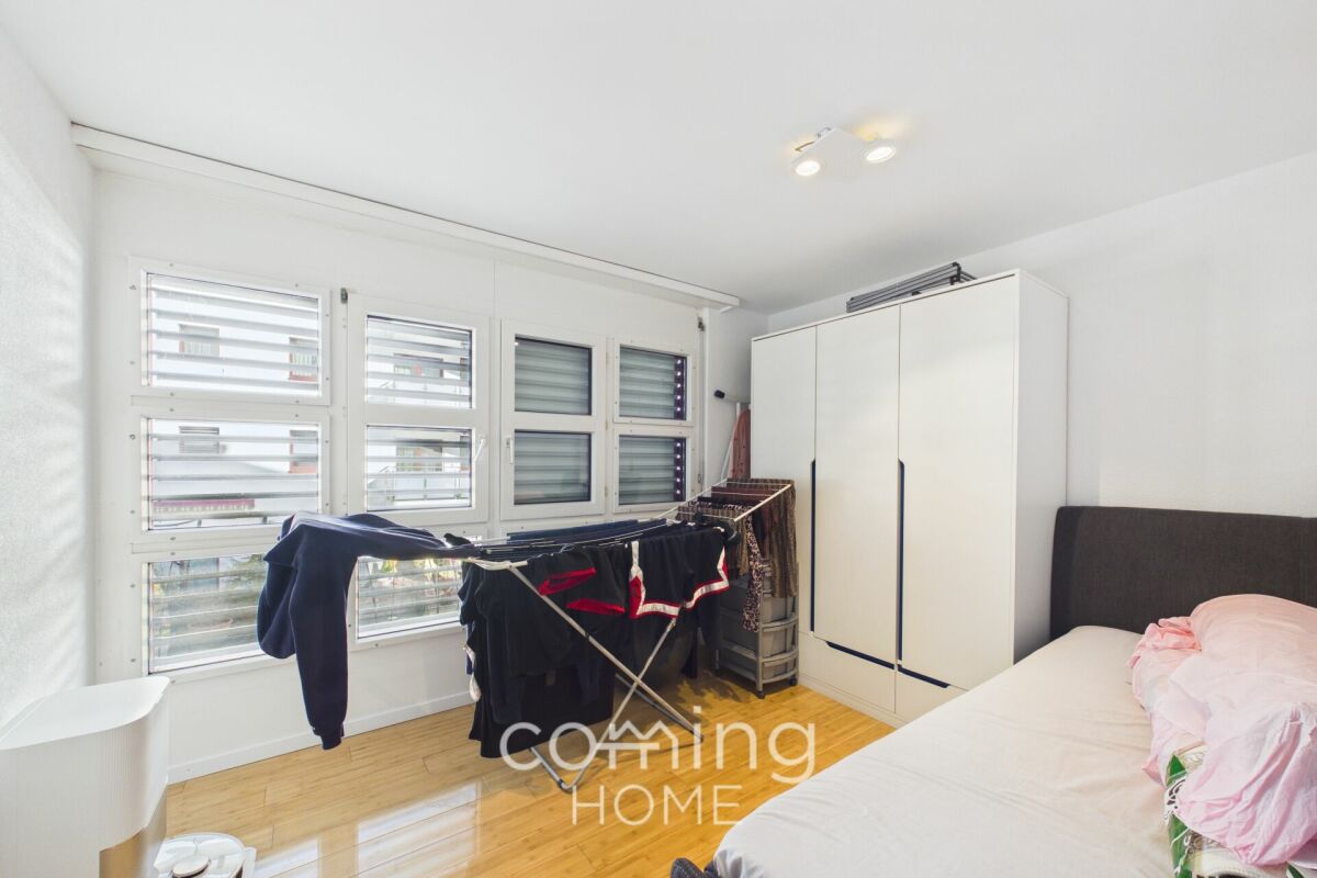 Helles Schlafzimmer mit Fenstern und Kleiderschrank