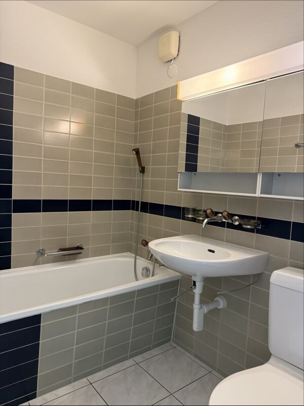 Kleines Badezimmer mit Badewanne und Waschbecken