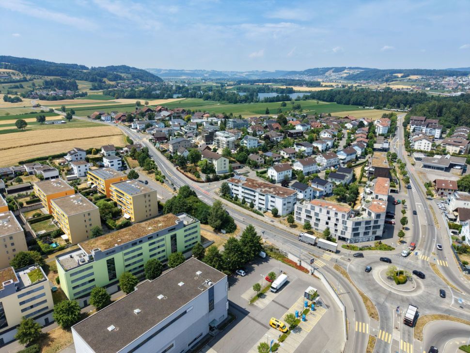 Luftaufnahme eines Wohngebiets mit Feldern und Straßenkreuzung