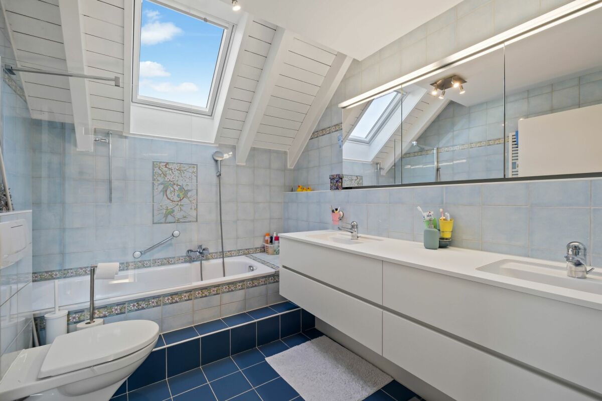 Helles Dachgeschoss-Badezimmer mit Badewanne und Doppelwaschtisch