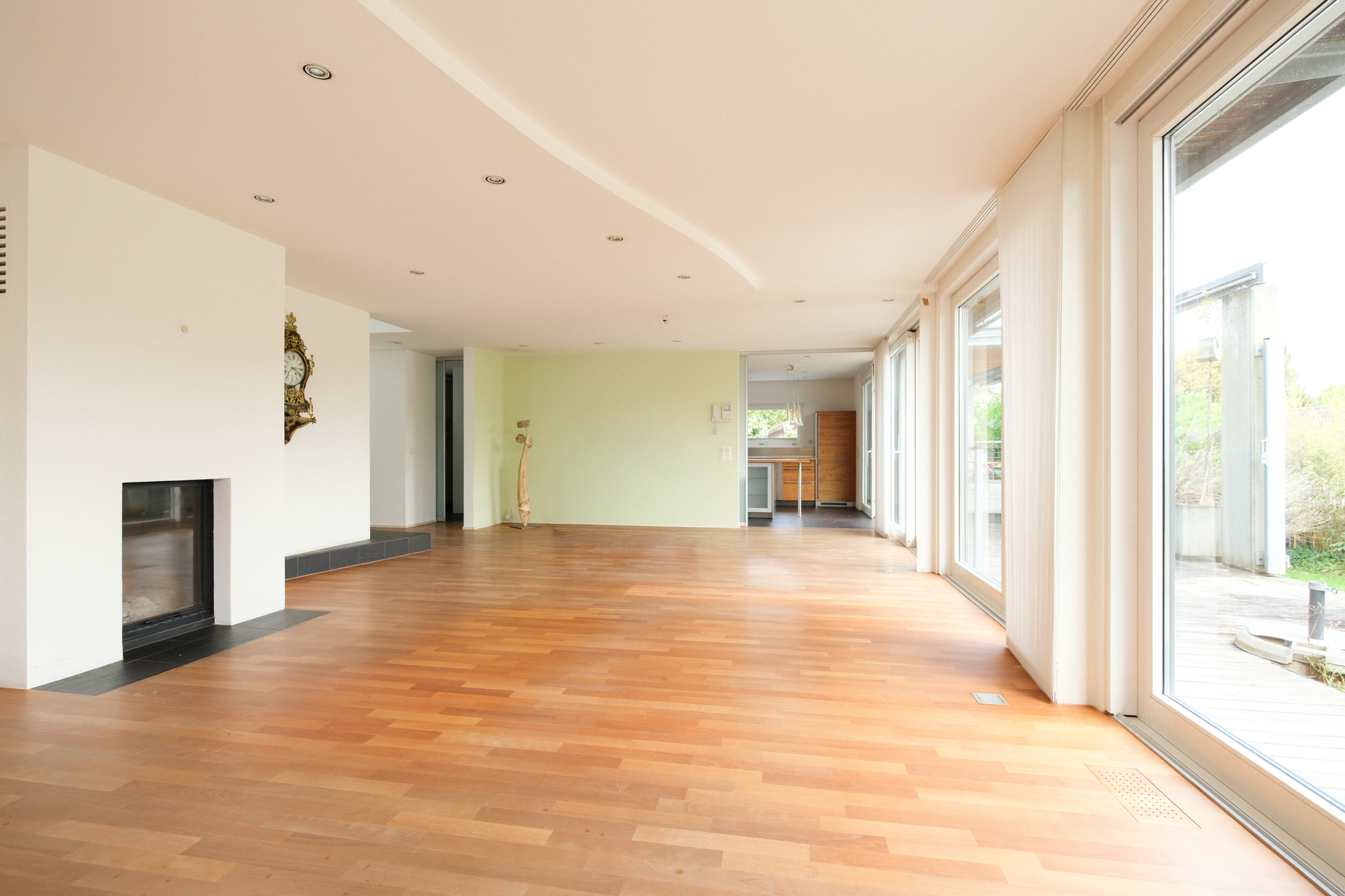 Großer, heller Wohnraum mit Kamin und bodentiefen Fenstern
