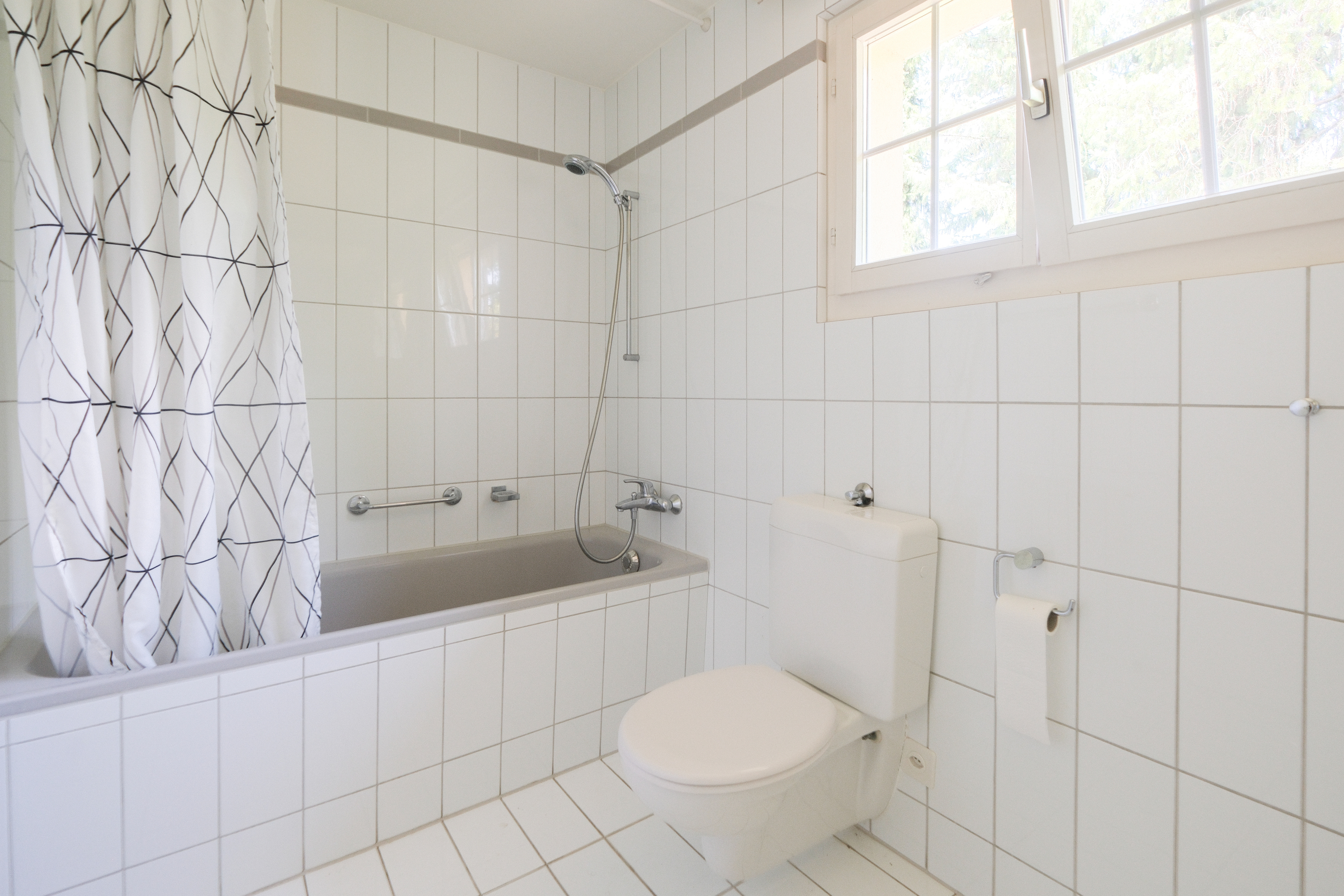 Helles Badezimmer mit Badewanne und WC