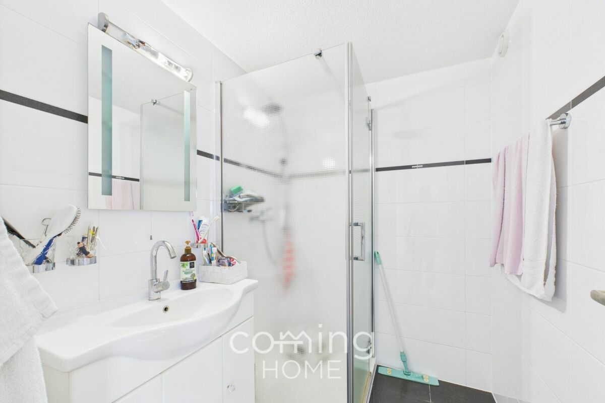 Modernes Badezimmer mit Glasdusche und Waschtisch