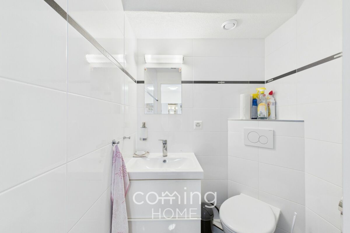 Kleines weißes Badezimmer mit Waschtisch und WC