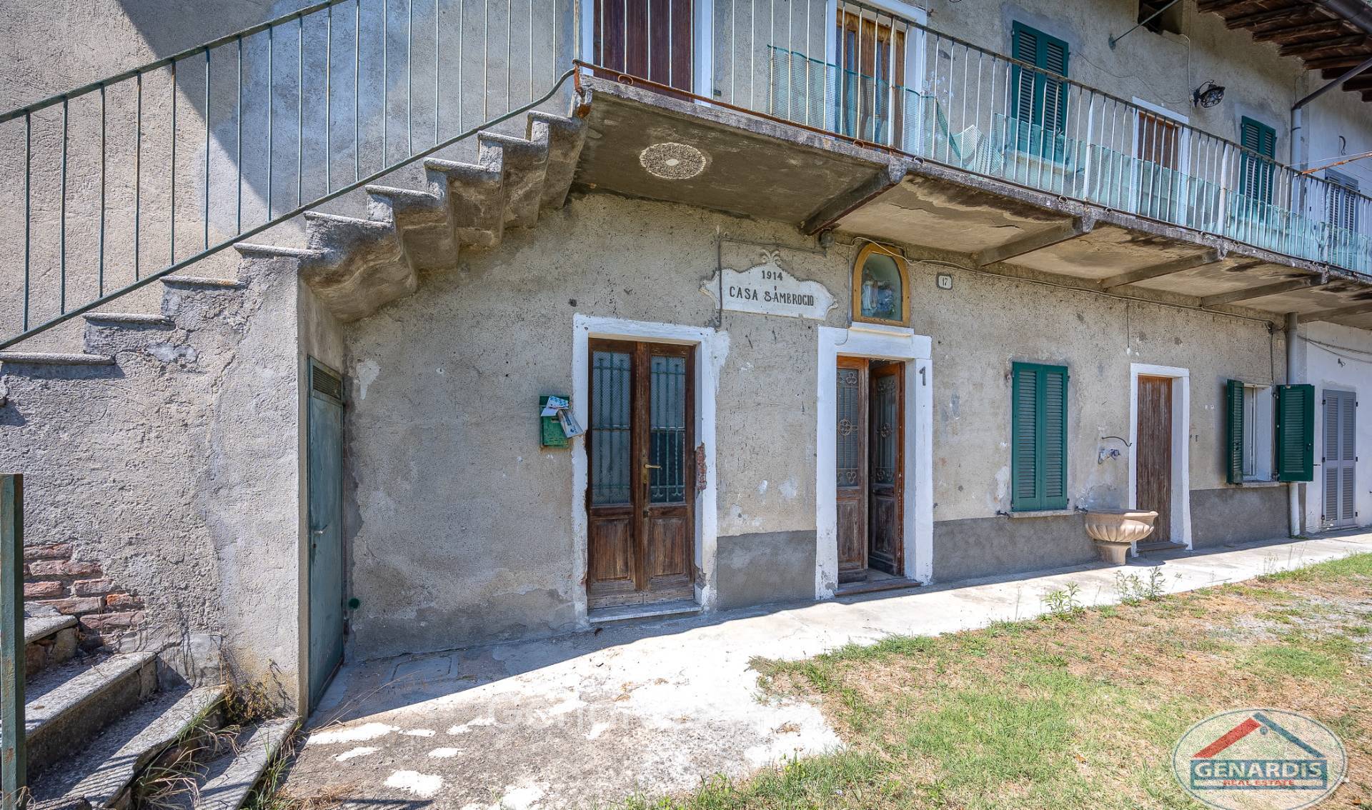 Historische Außenansicht eines Hauses mit Balkon und Klappläden