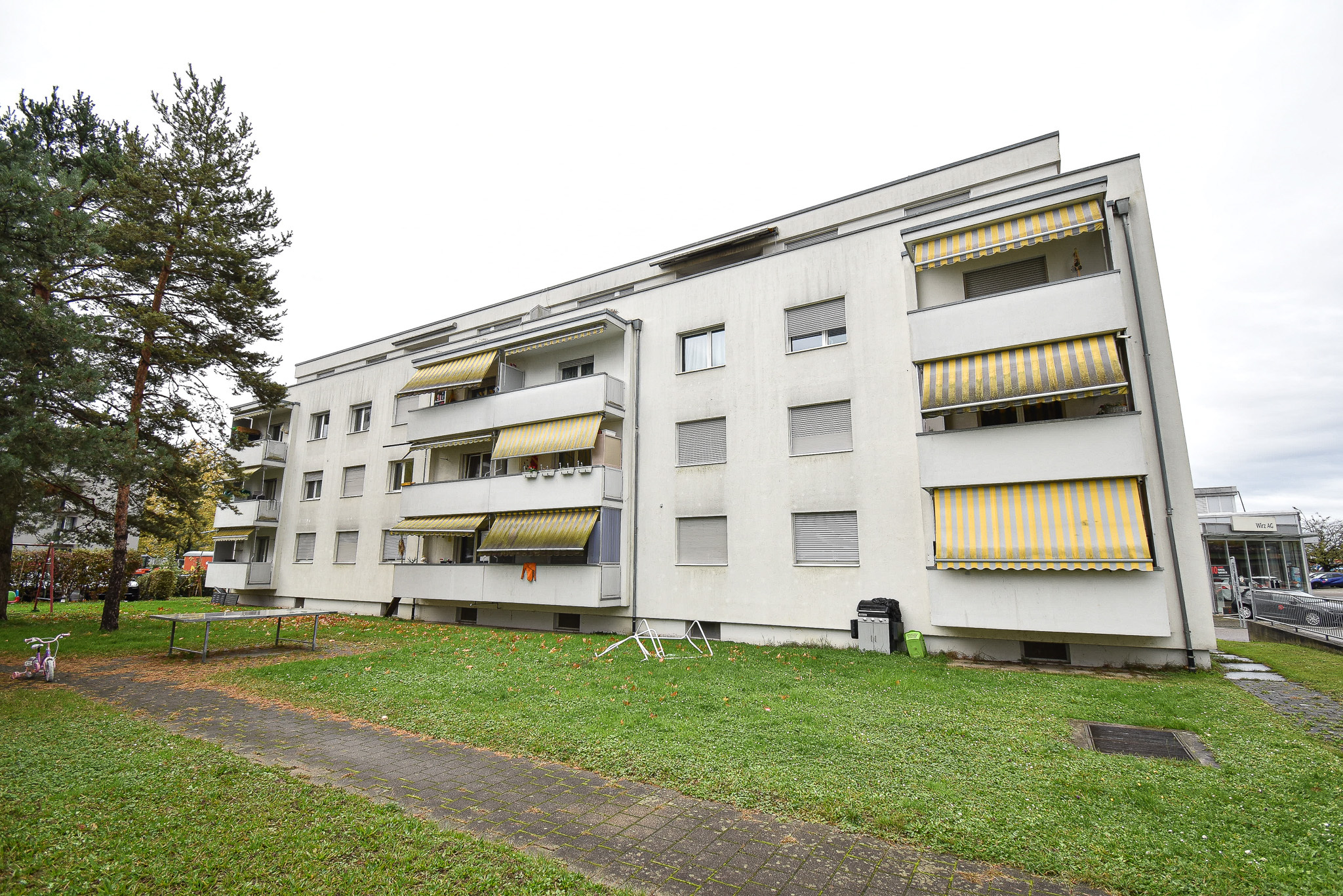 Mehrfamilienhaus mit Balkonen und Markisen