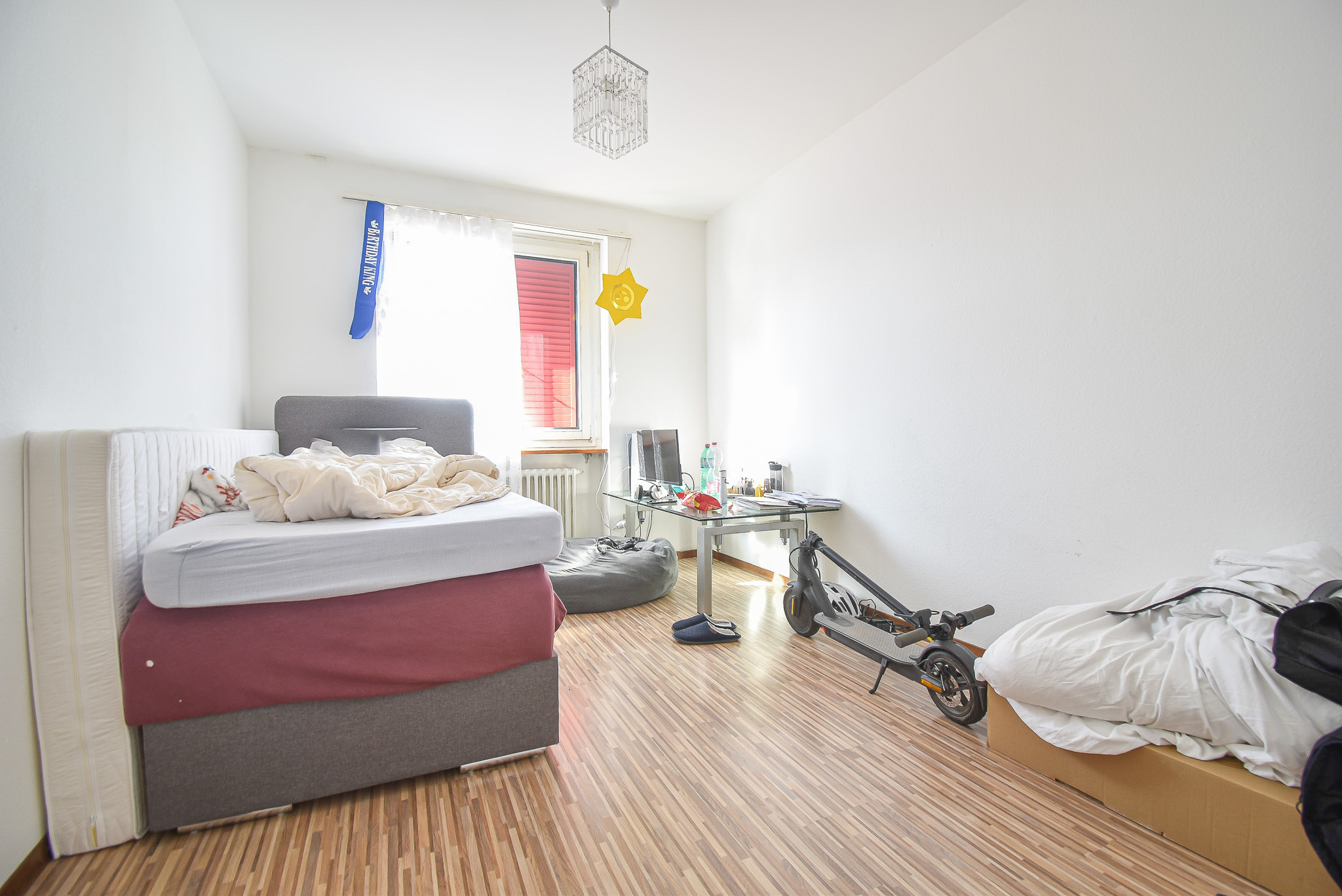 Helles, schlichtes Schlafzimmer mit zwei Betten und Arbeitsbereich