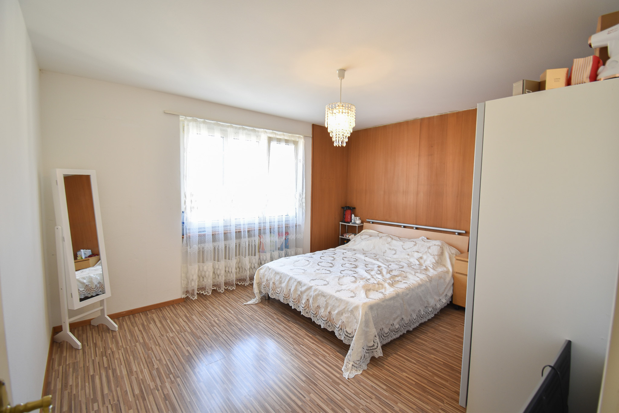 Helles Schlafzimmer mit Holzwand und Einzelbett